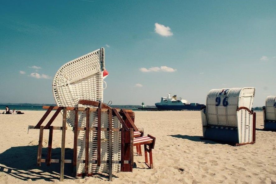 Zwei Strandkörbe an einem Strand und Schiff im Hintergrund