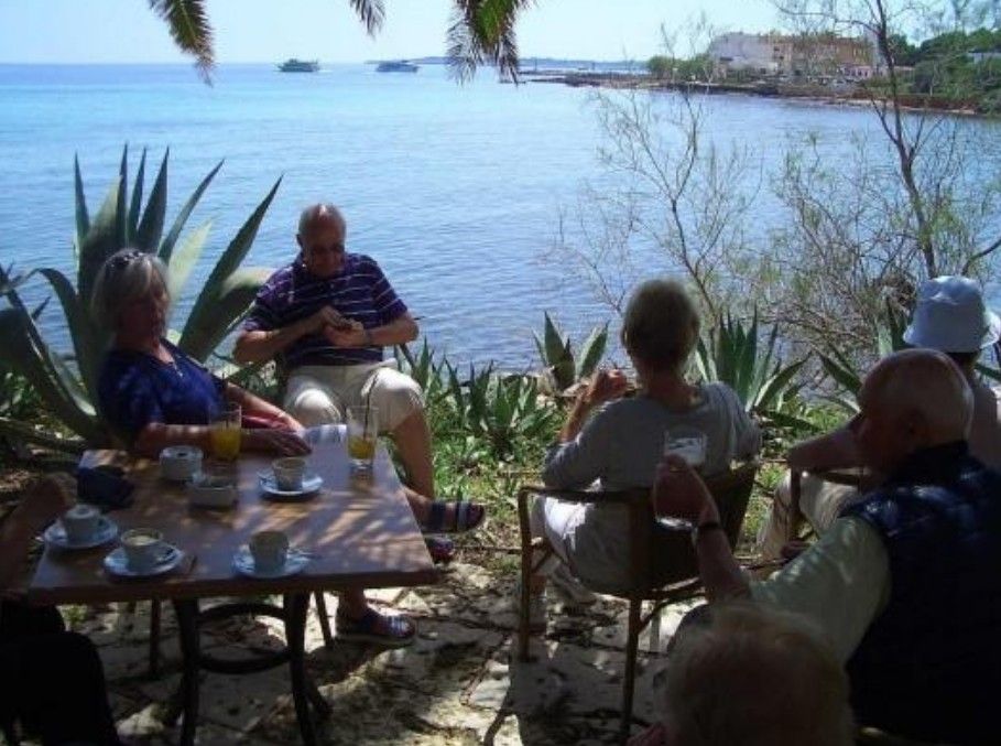 Mehrere Menschen trinken Kaffee am Meer