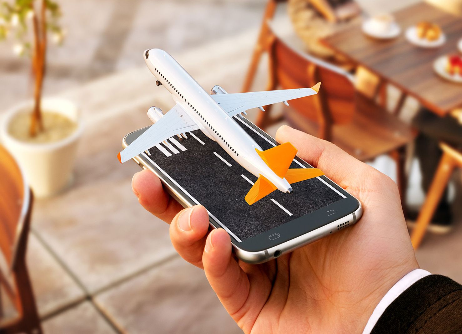 Ein Handy aus dem ein kleines Flugzeug startet