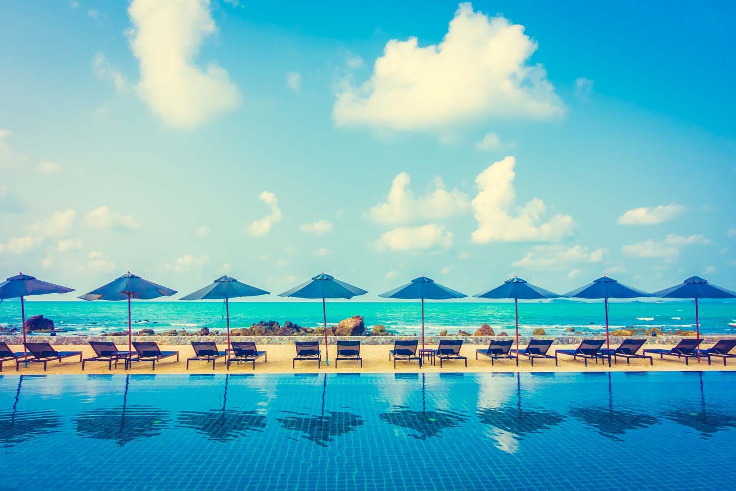 Mehrere Liegen am Meer mit Pool