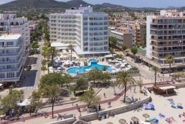 Eine Luftaufnahme von einer Hotelanlage mit Stand und Pool