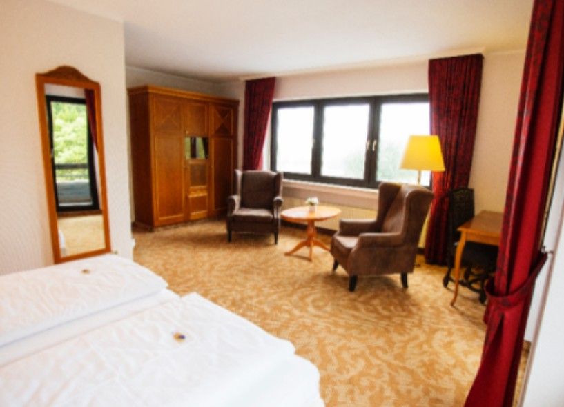 Ein Hotelzimmer mit einem Bett und zwei Sessel