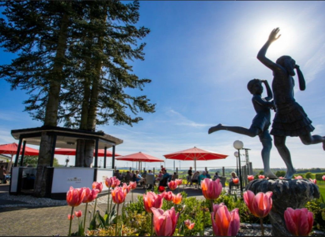 Ein Pavilion mit Blumen und einer Statue von zwei Kindern davor